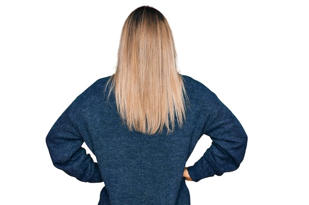 Young caucasian woman wearing casual clothes standing backwards looking away with arms on body