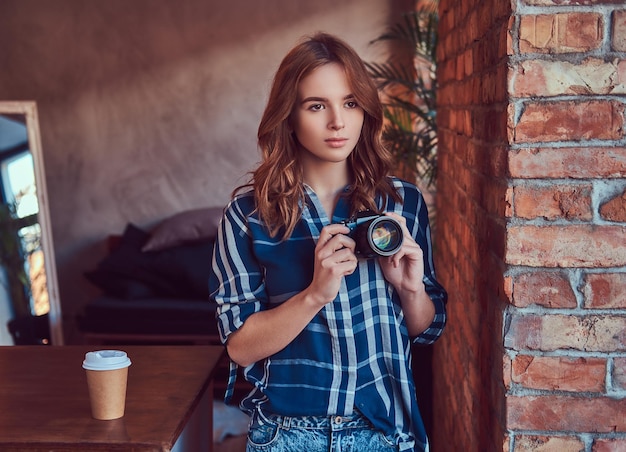 Free Photo young charming girl photographer stands in a room with a loft in