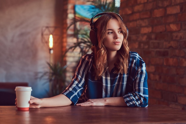 A young charming sensual girl listening to a music in headphones