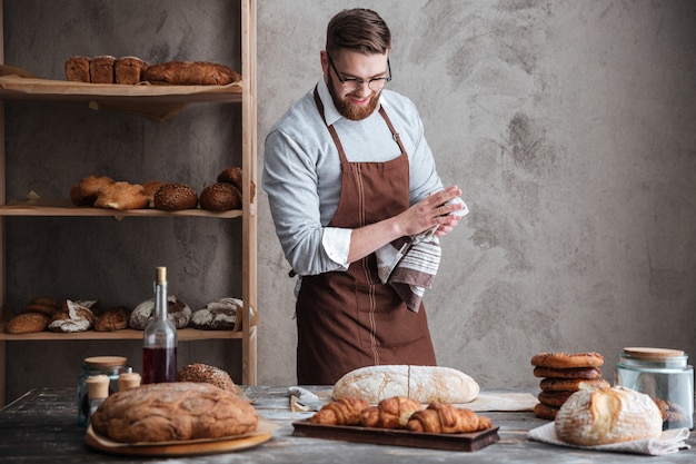 Free photo young cheerful bearded man wearing glasses baker