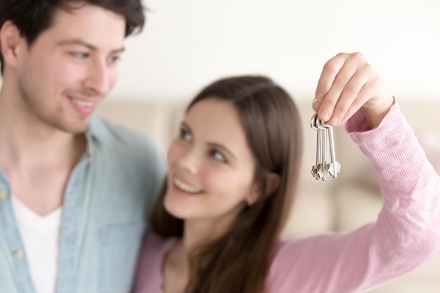 Young cheerful couple holding new house keys