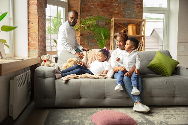 Young and cheerful family during quarantine, insulation spending time together at home.