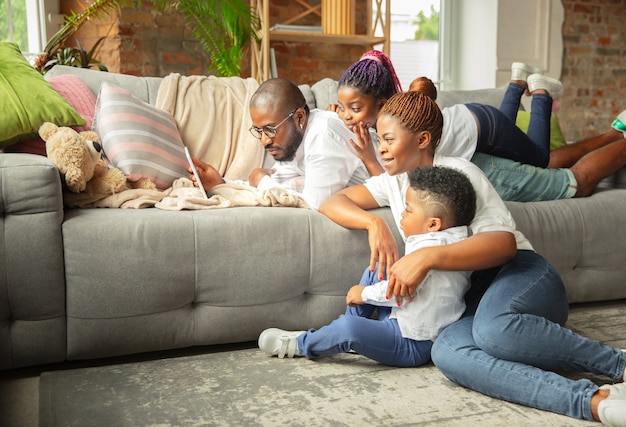 Young and cheerful family during quarantine, insulation spending time together at home.