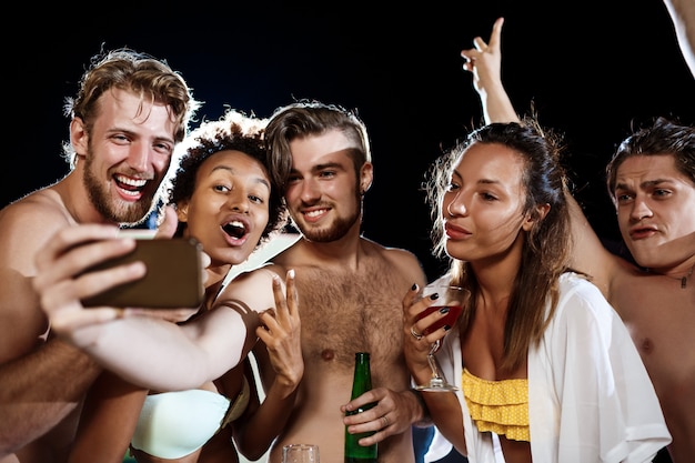 Free Photo young cheerful friends smiling, rejoicing, making selfie, resting at party