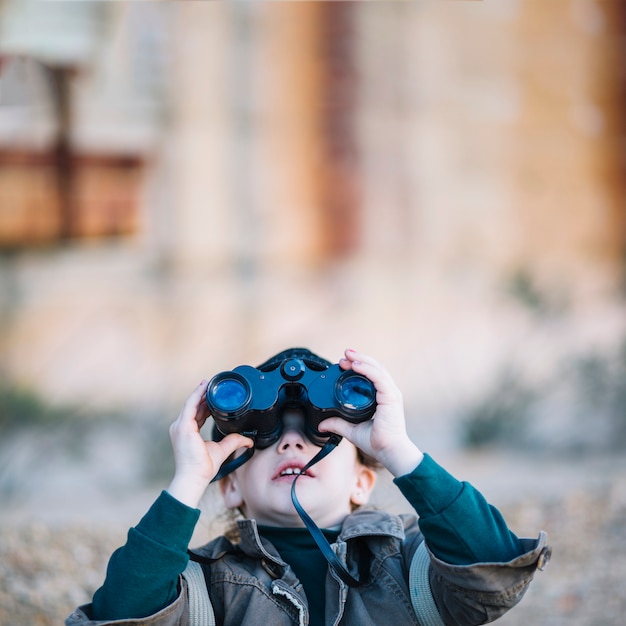 Free Photo young child looking through binoculars