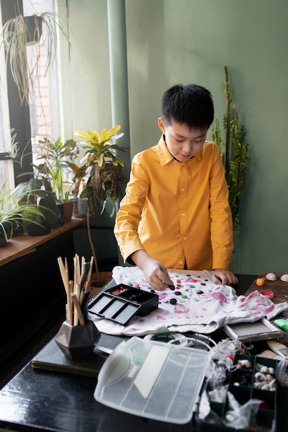 Free photo young child making diy craft project with t-shirt