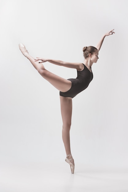 Free photo young classical dancer dancing on white background. ballerina project.