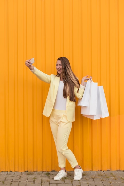 Free photo young client wearing yellow clothes and taking a selfie