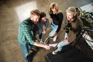 Free photo young colleagues in office talking with each other holding notebook