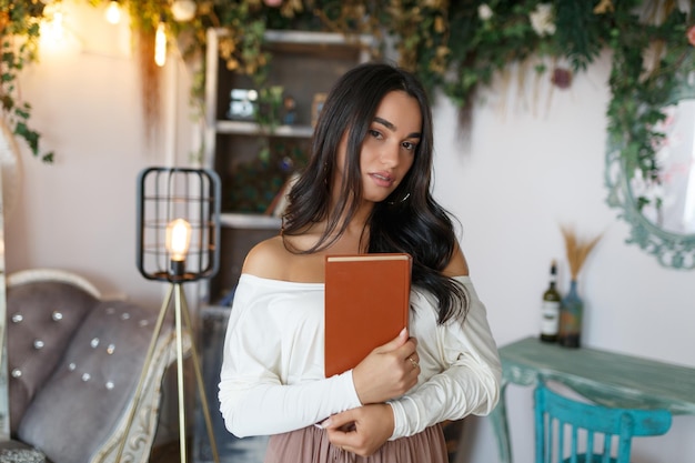 Young confident girl hugged her book and looking at the camera High quality photo