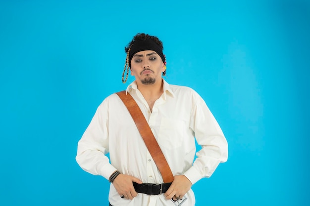 Free photo young confident pirate put his hands to his belt and looking at the camera. high quality photo