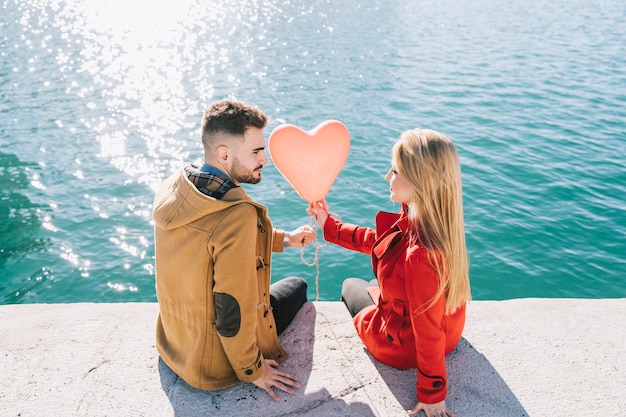 Young content couple posing with balloon