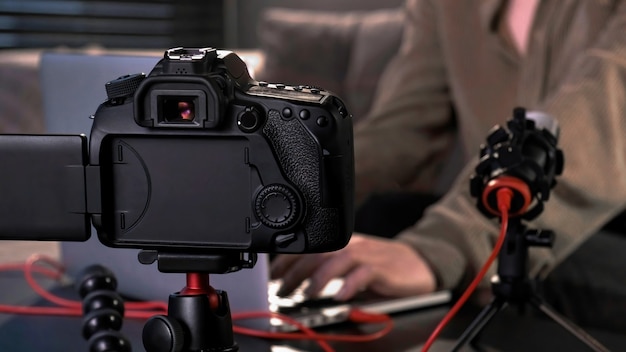 Young content creator girl filming herself using a camera on a tripod and microphone