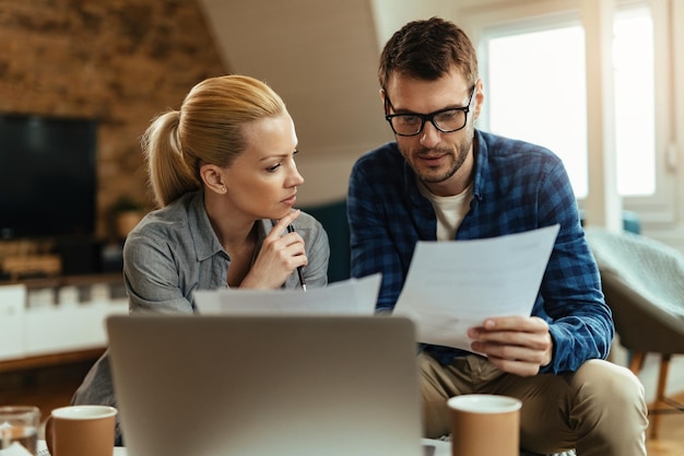 Free photo young couple analyzing their budget while going through home finances