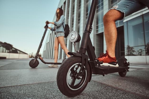 Young couple are making interesting composition from their scooters while posing for photographer.