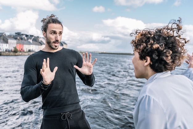 Free photo young couple arguing expressively with the unfocused  sea