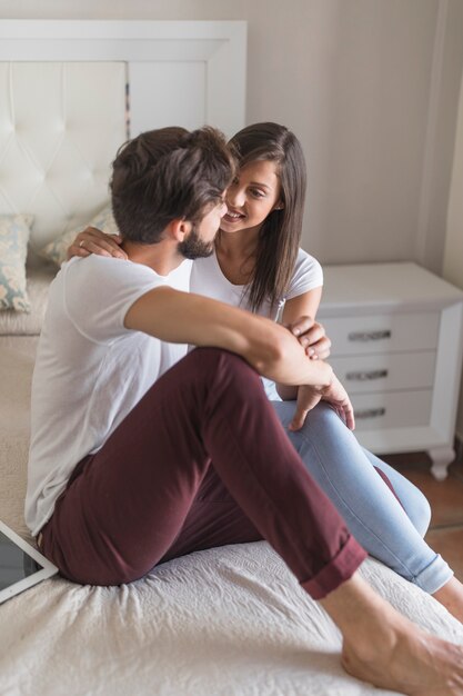 Young couple on bed looking at each other