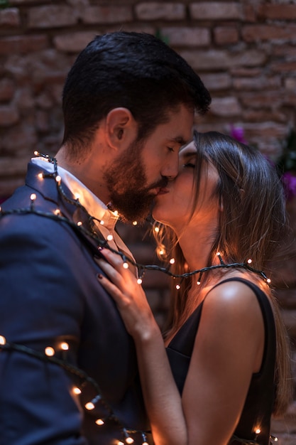 Young couple in burning garland kissing