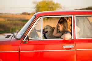 Free photo young couple in car with their dog