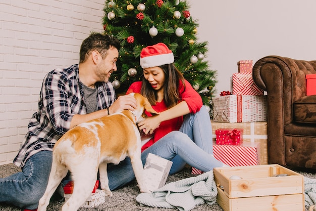 Free photo young couple celebrating christmas with dog