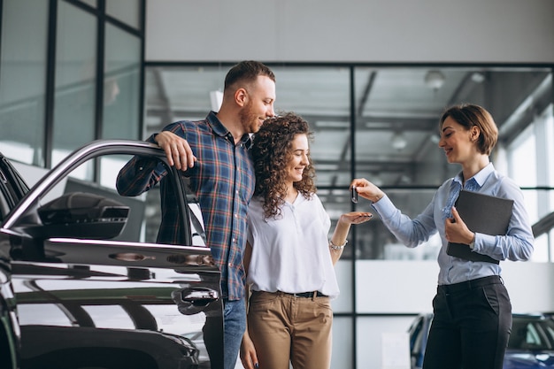 Young couple choosing a car in a car show room