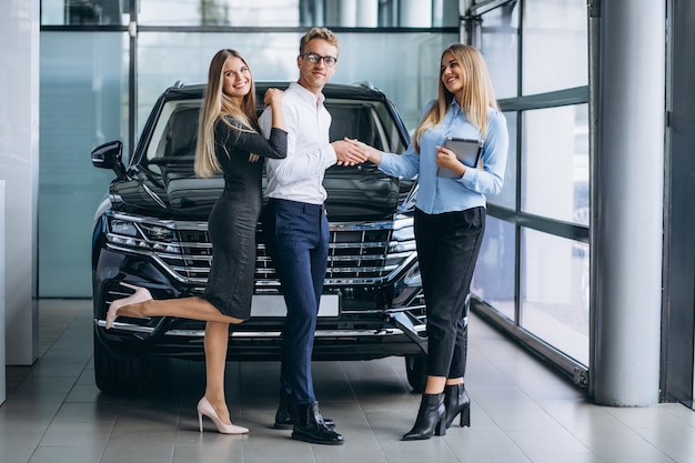 Young couple choosing a car in a car show room