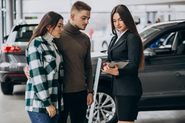 Young couple choosing a car in a car show room