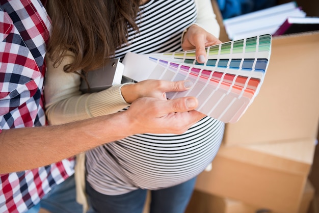 Free Photo young couple choosing color for baby's room