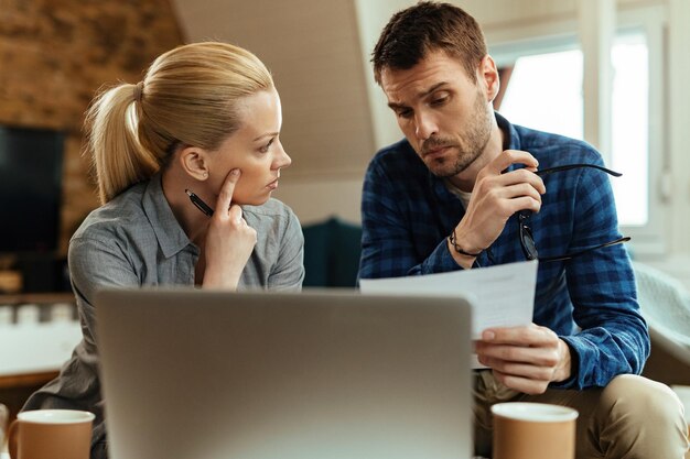 Young couple communicating while going through their home finances