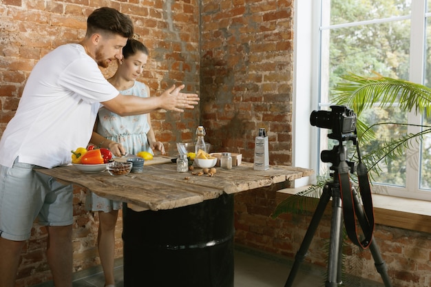 Free photo young couple cooking and recording live video for vlog and social media