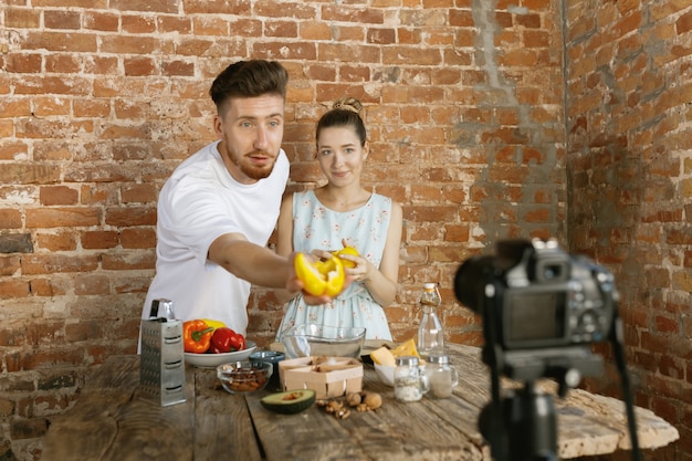 Free photo young couple cooking and recording live video for vlog and social media