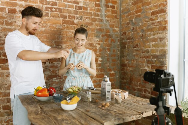 Free photo young couple cooking and recording live video for vlog and social media