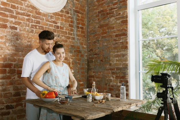 Young couple cooking and recording live video for vlog and social media