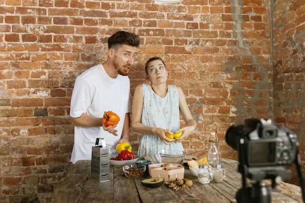 Free photo young couple cooking and recording live video for vlog and social media