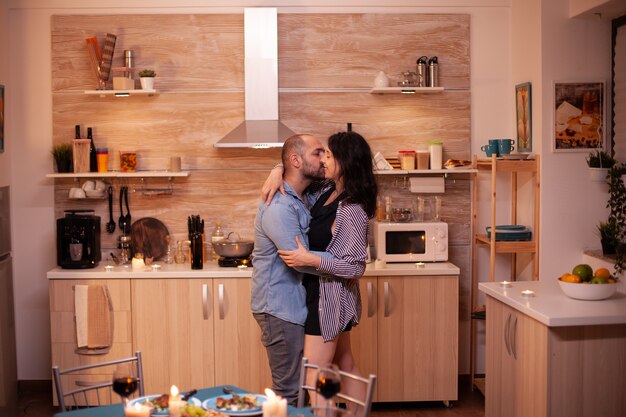 Young couple dancing in kitchen during romantic dinner