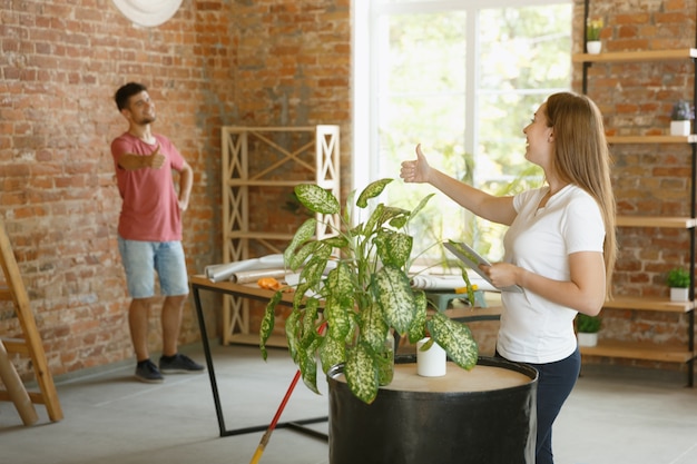 Free Photo young couple doing apartment repair together themselves. married man and woman doing home makeover or renovation. concept of relations, family, love. checking done design, put new furniture.