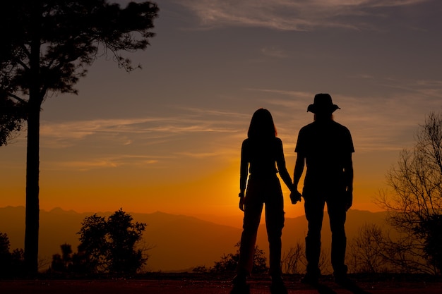 Young couple enjoying the sunset in the mountain