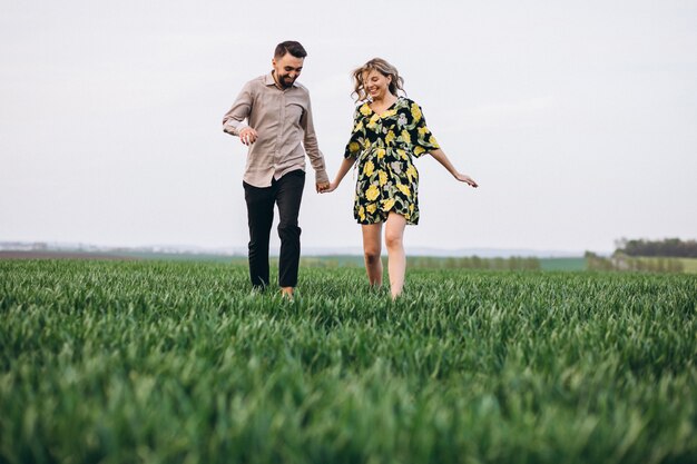 Young couple in the field with green grass