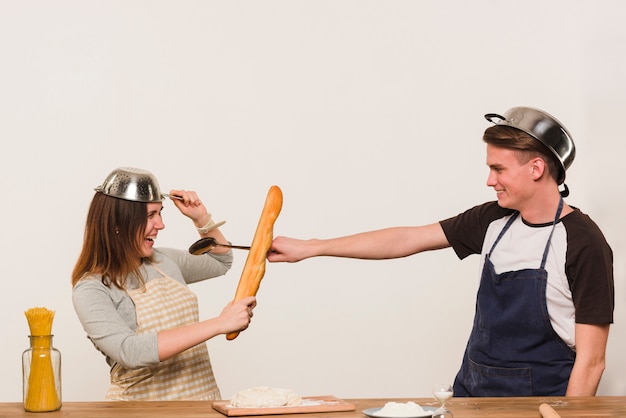 Young couple fooling around while cooking in kitchen