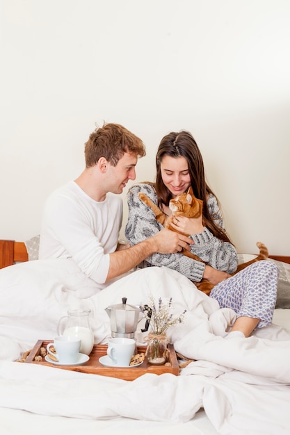 Young couple having breakfast in bed