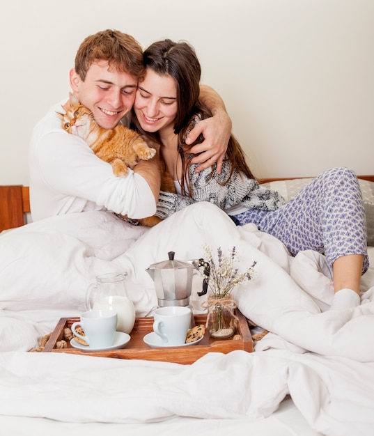 Free Photo young couple having breakfast in bed