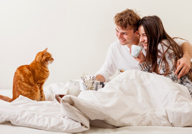 Young couple having breakfast in bed