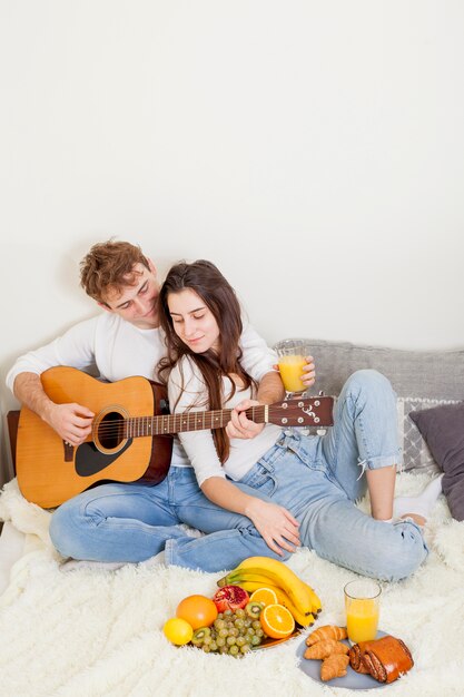 Young couple having breakfast in bed