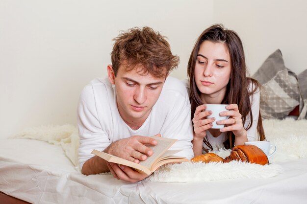 Young couple having breakfast in bed