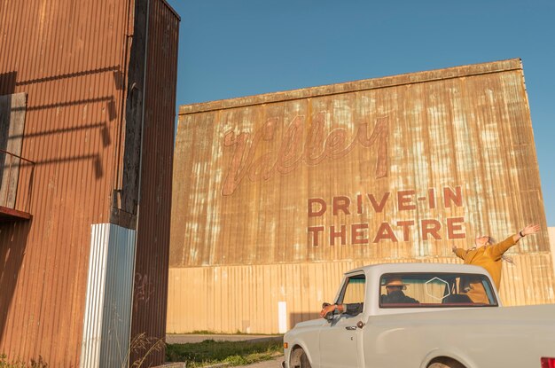 Young couple having fun on their car trip at a drive-in theatre