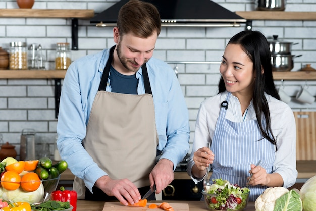 Young couple having fun while preparing food in kitchen