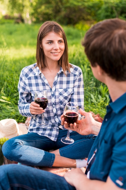 Young couple having picnic and holding wineglasses