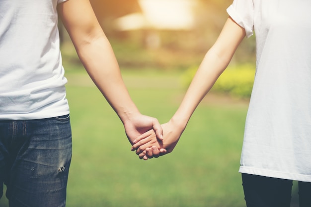 Young Couple Holding Hands Walking Away together