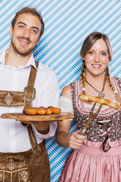 Free Photo young couple holding oktoberfest snacks