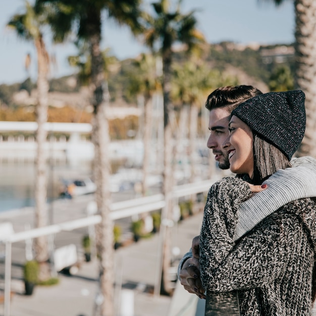 Young couple hugging in front of palm trees